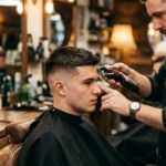 Barbier schneidet einem jungen Mann eine moderne Fade Frisur